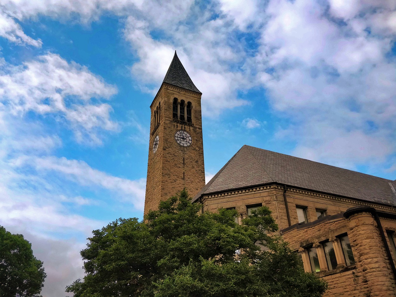 image of clock tower of cornell university with a blue sky behind