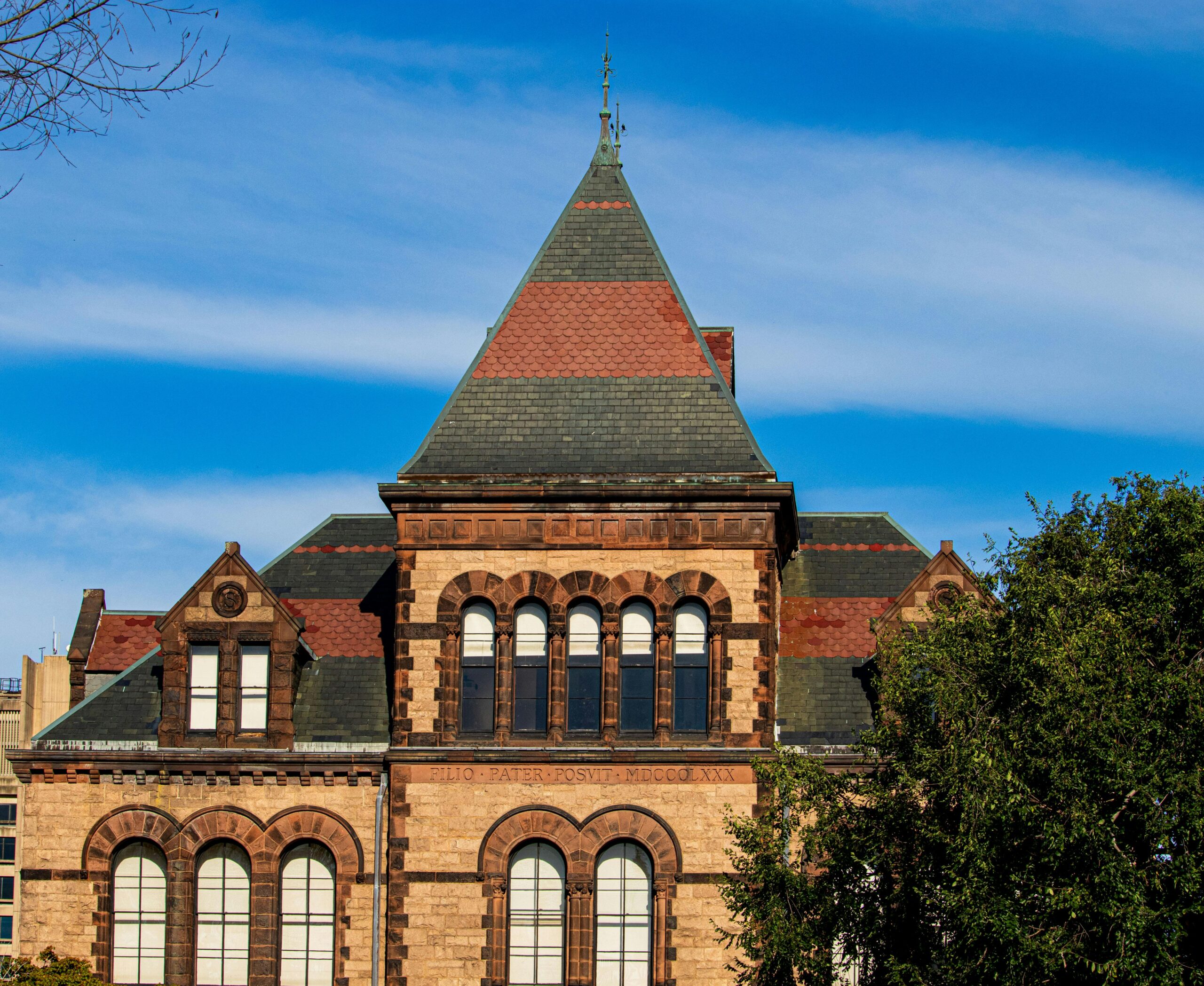 tan brick campus building with tall arched windows