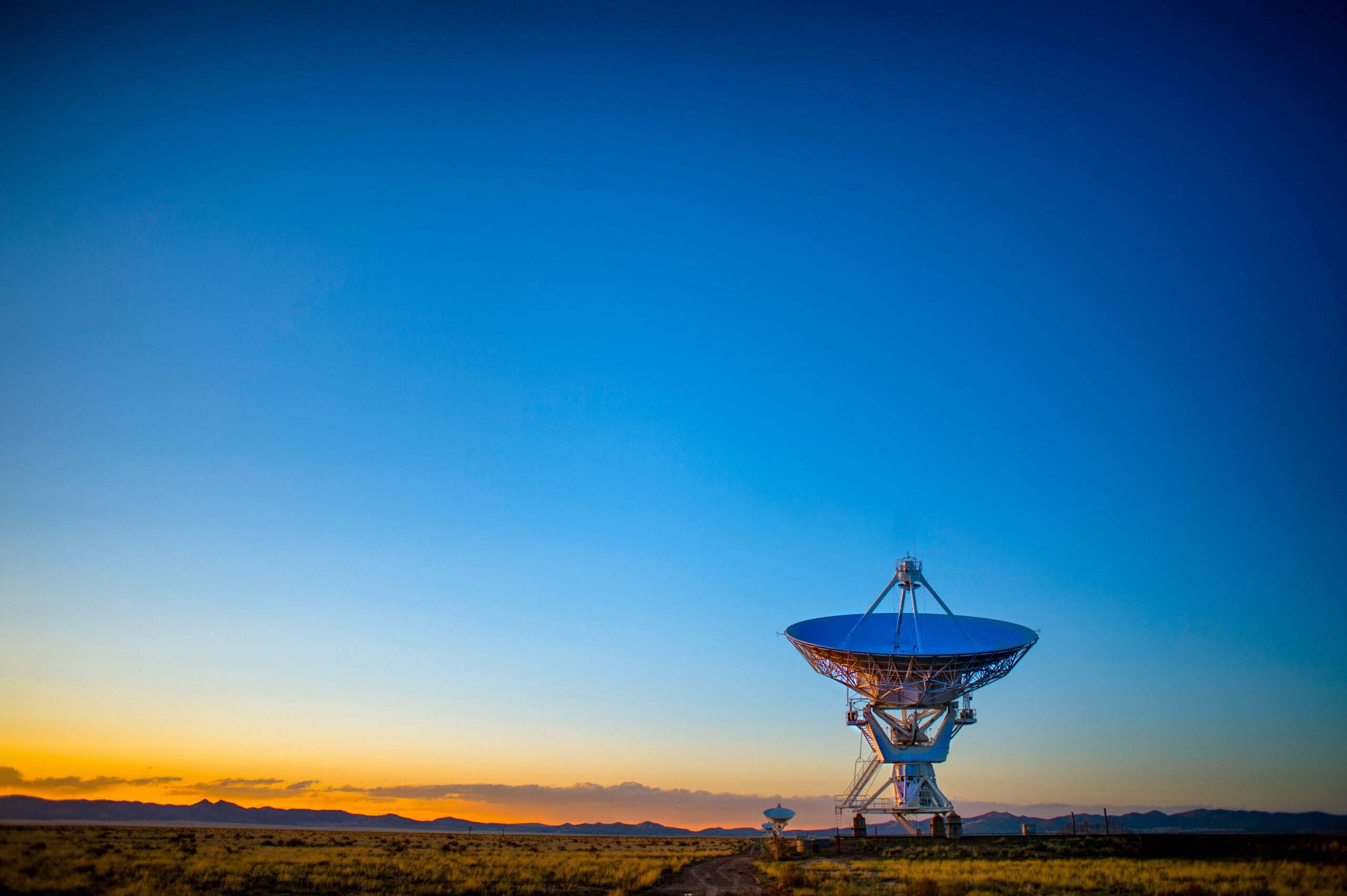 Large grey satellite disc in field at sunrise