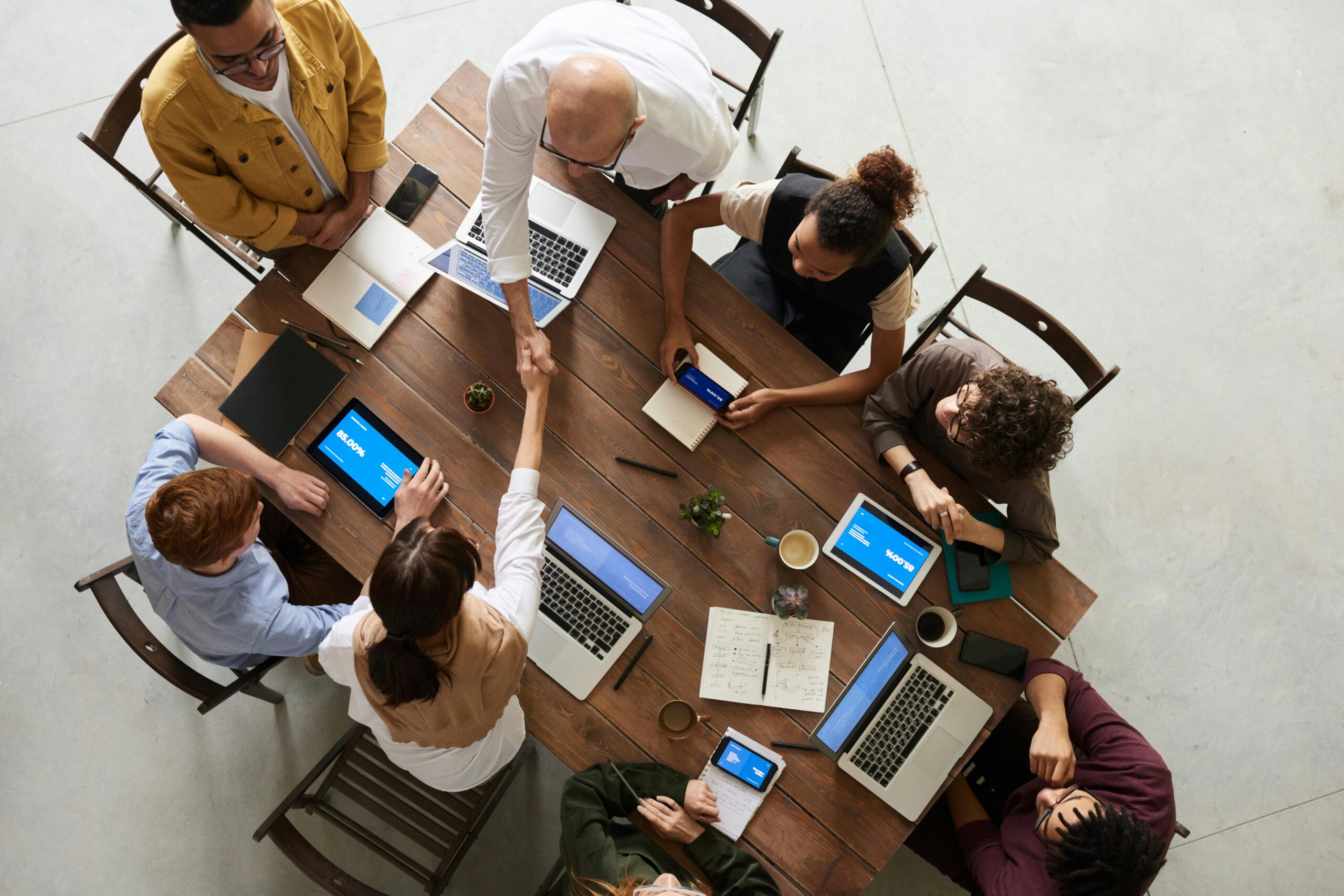 Birds-eye view of business people around table with laptops and office supplies