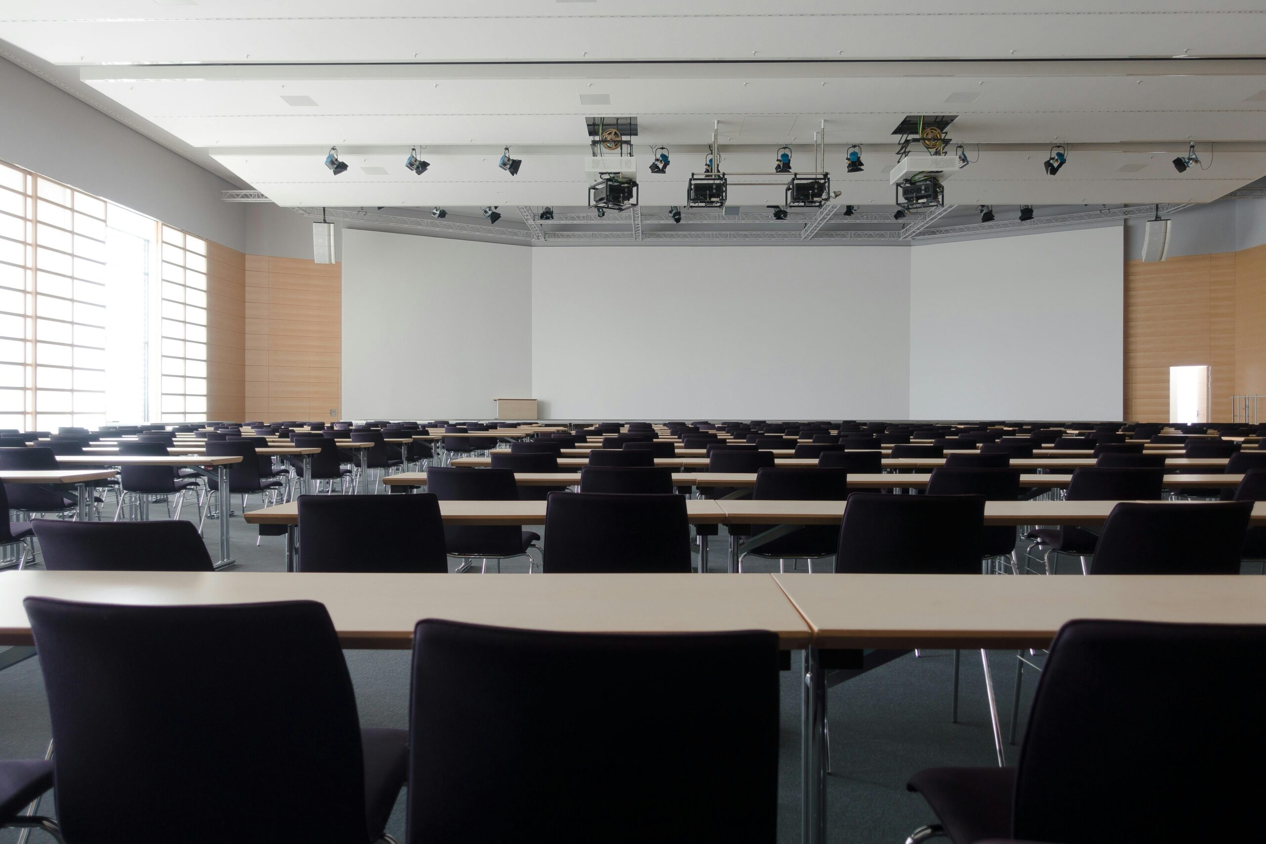 classroom with rows of chairs and tables facing lecture board