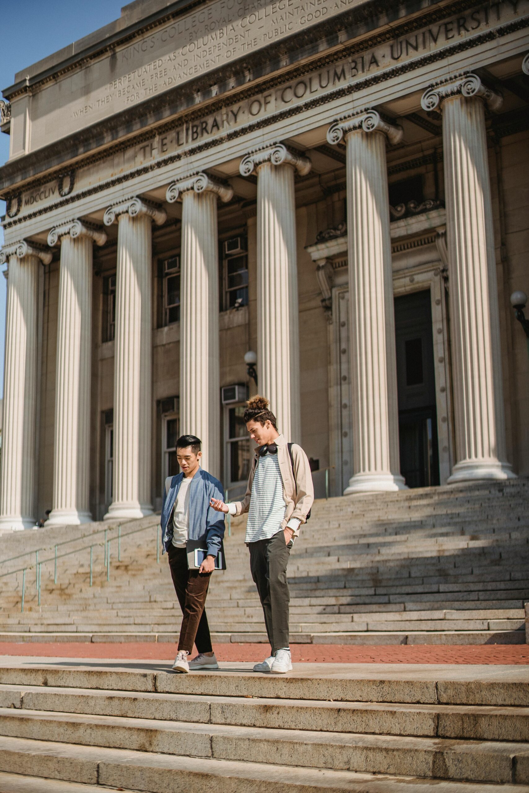 two students walking down front steps to Columbia University library