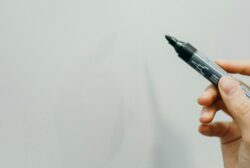 hand holding marker against white board