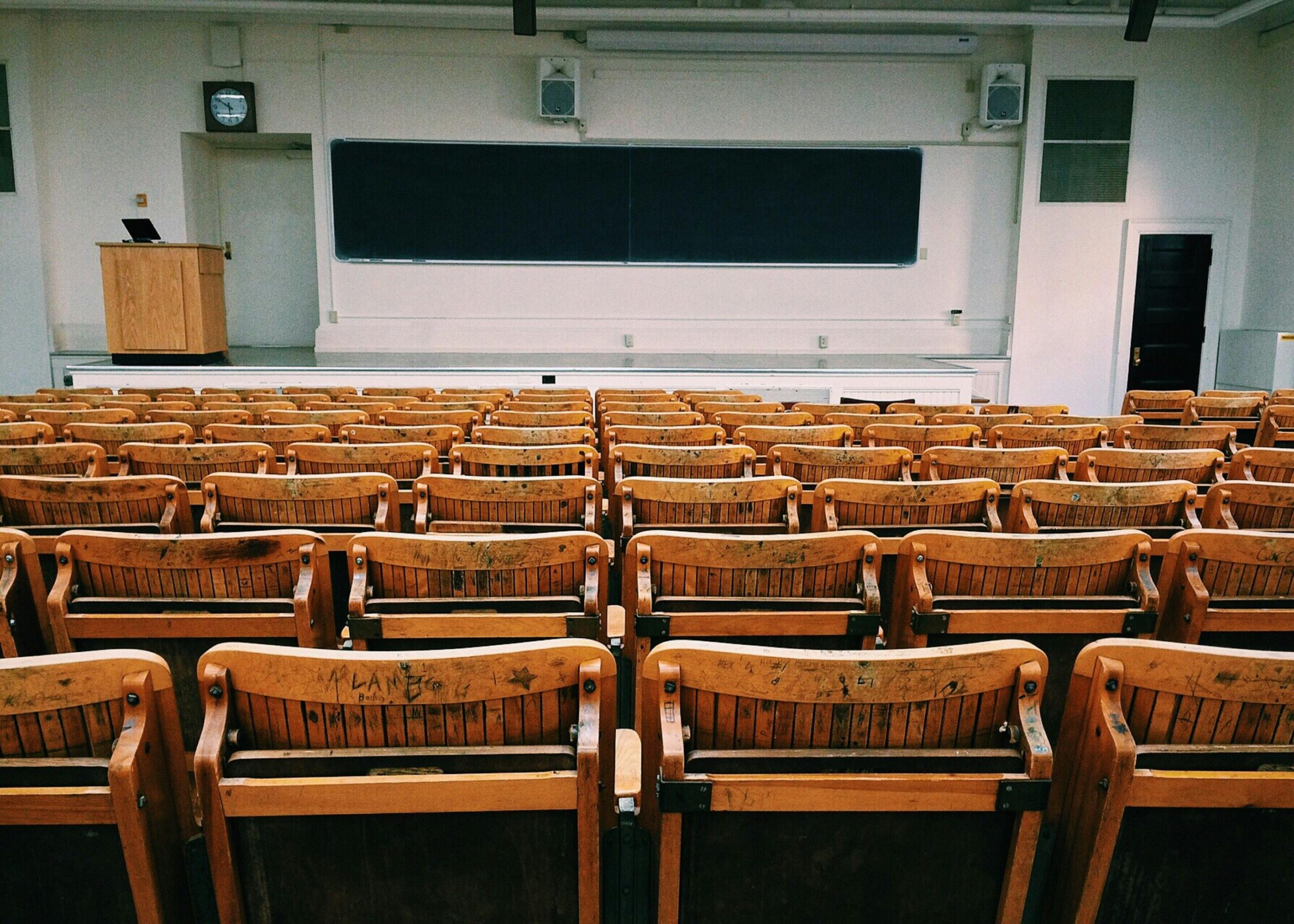 rows of wooden seats in empty lecture hall