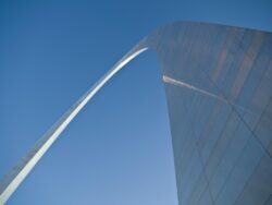 Image of St Louis arch taken from the bottom looking up against a blue sky backdrop