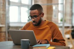man with glasses looking at computer screen