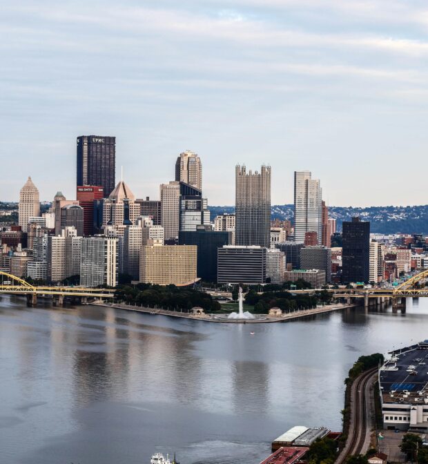 Pittsburgh skyline on the Ohio river with gray sky in background.