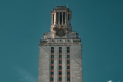 Top of UT Austin clock tower against a blue sky