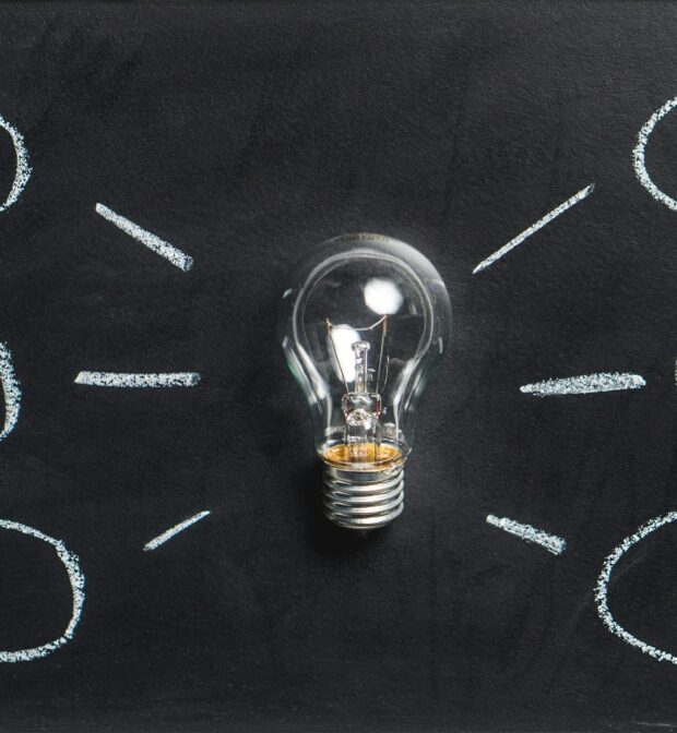 Lightbulb on a chalkboard with ideas branching off of it