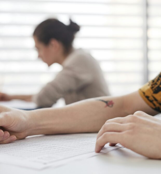 A Person Writing on a Paper Using Pencil
