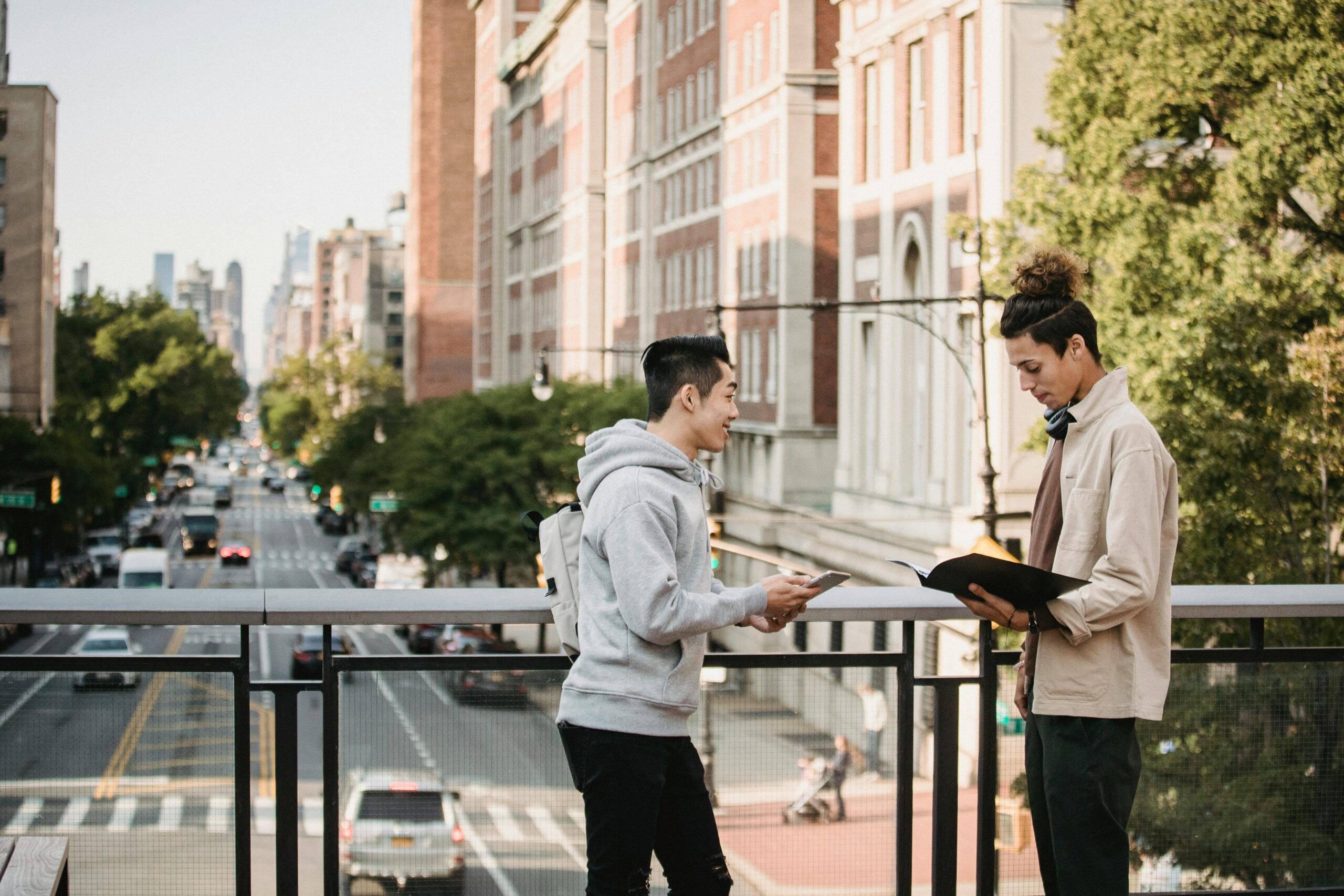 Multiracial students preparing for exam on bridge of city