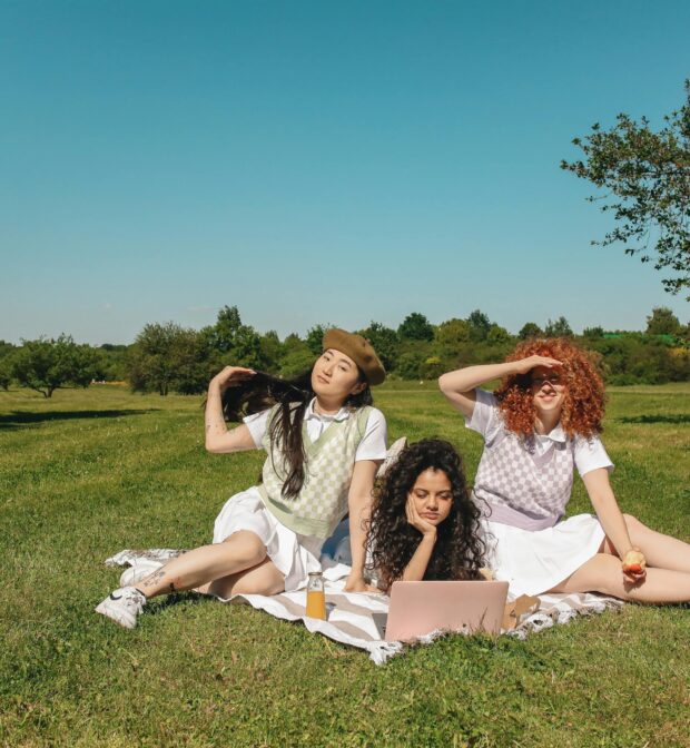 A Group of Women Sitting on a Grassy Field