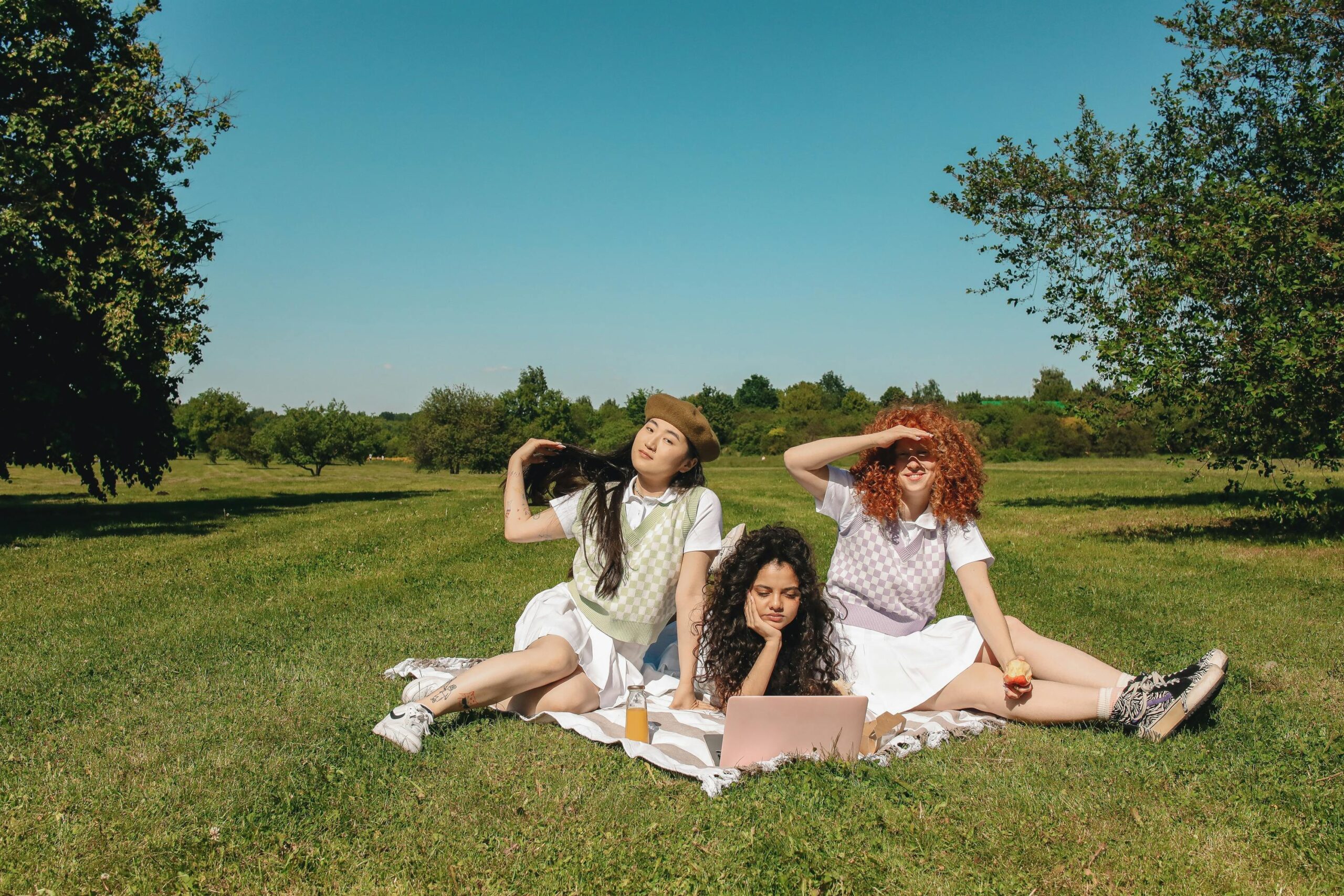 A Group of Women Sitting on a Grassy Field