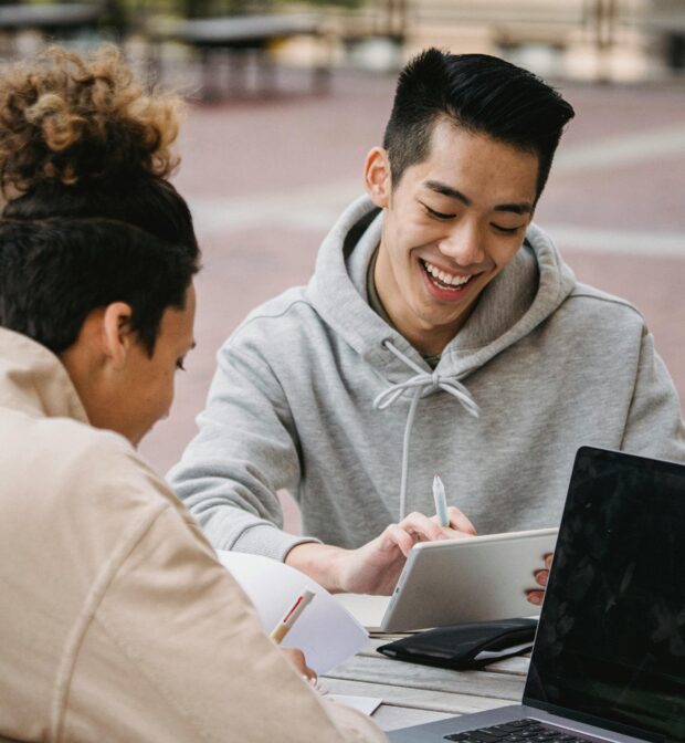 Laughing men working on assignment together
