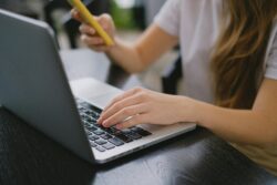 A Person in White Shirt Using a Laptop