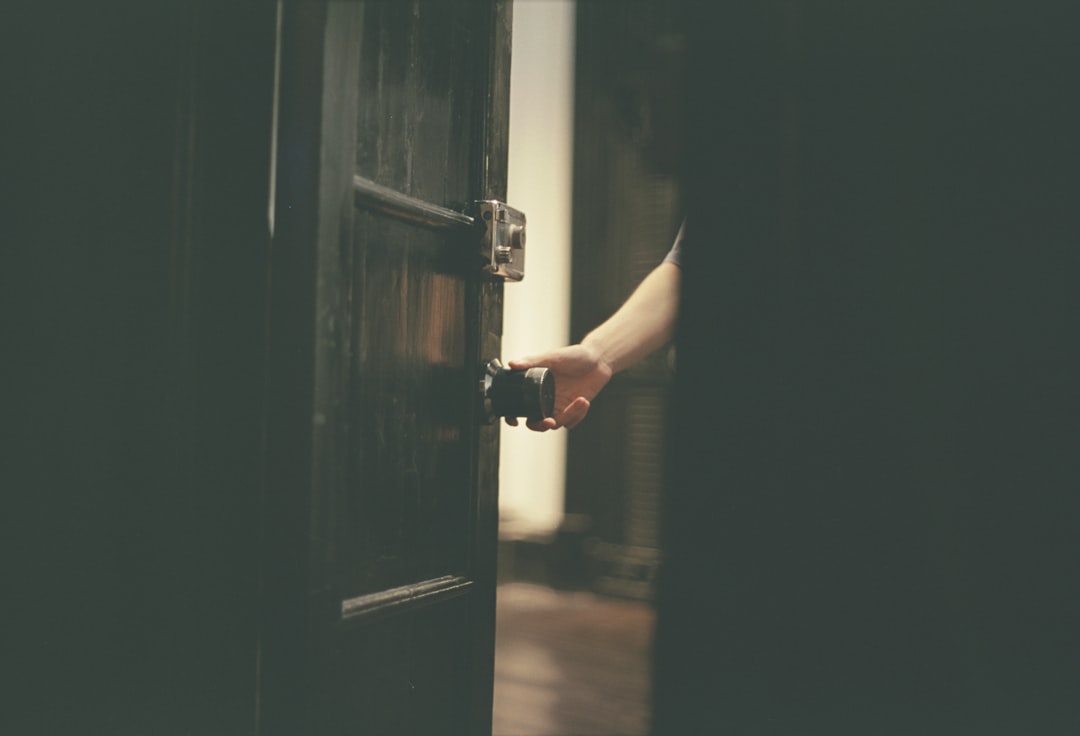a person opening a door with their hand